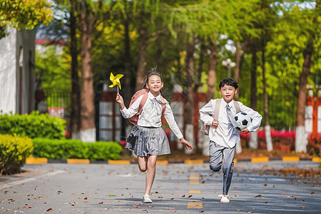 小男孩背书包小学生放学踢足球背景