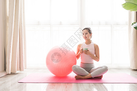 女性瑜伽球休息女性瑜伽休息喝水背景