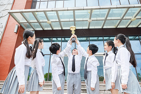 小学生团体手捧奖杯背景图片