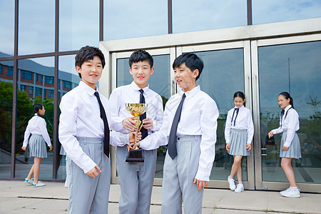 小学生团队手拿奖杯高清图片