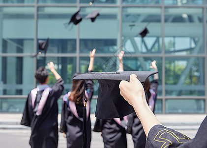 抛学士帽大学毕业生手拿学士帽背景