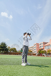 小学生照片小学生操场上拿远镜观望背景