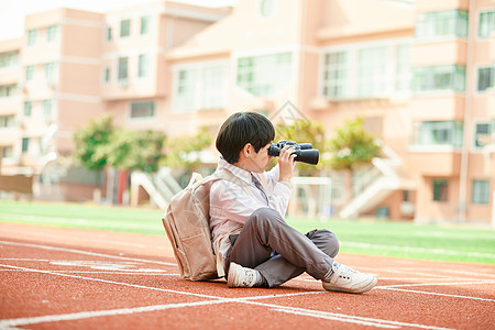 小学生拿相机小学生操场玩望远镜背景