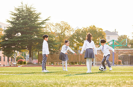 小学生操场踢足球背景图片