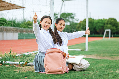 穿校服女同学小学生操场看书背景