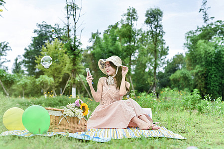 野餐中玩手机的美女高清图片