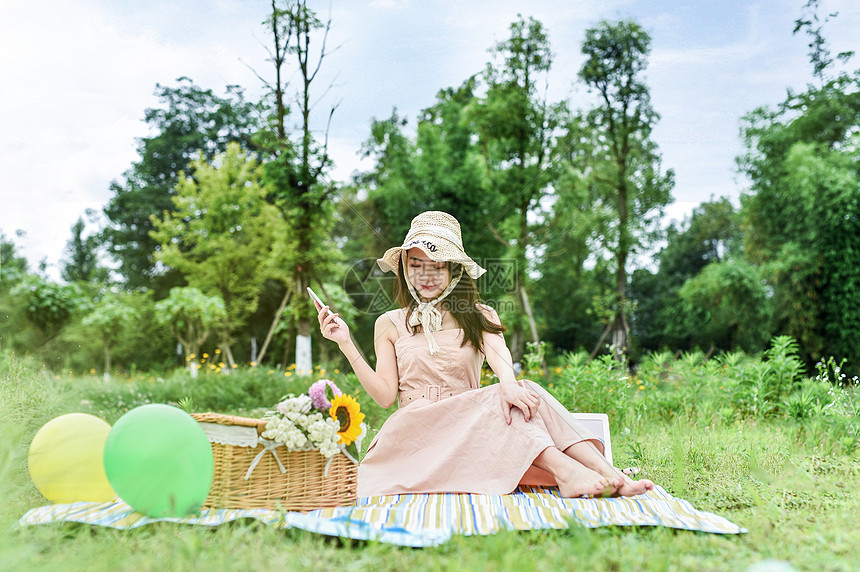 草地上坐着玩耍的美女图片