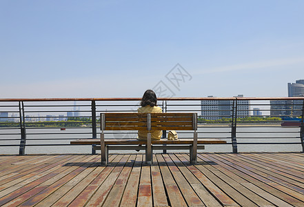 一个坐在江边思考的女人背影图片