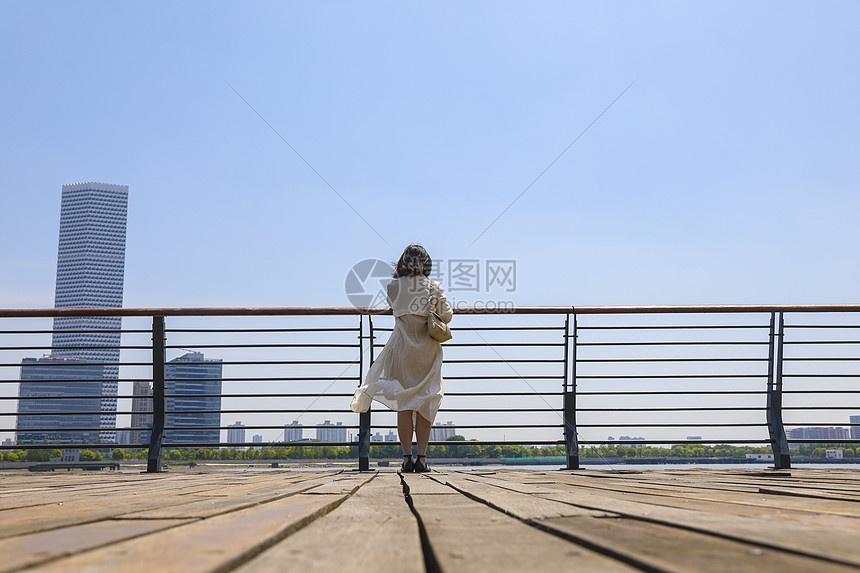 一个在江边观赏风景的女人背影图片