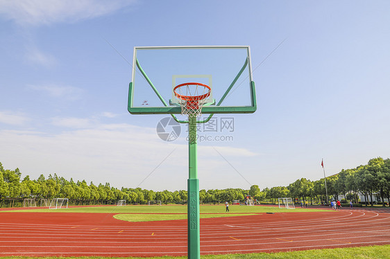 学校操场为背景的篮球场上的篮球架图片