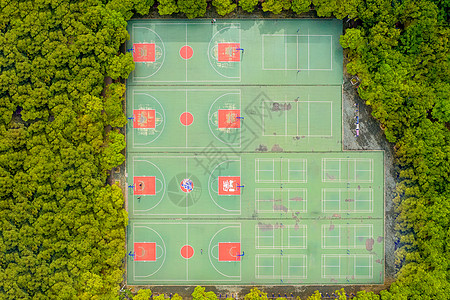 小区篮球场航拍城市楼盘小区绿树环绕的运动场背景