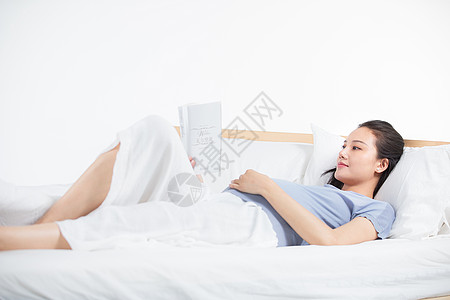 孕妇躺床上看书图片