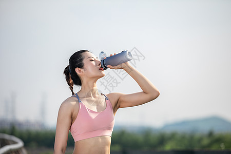 运动擦汗女性户外运动健身喝水背景