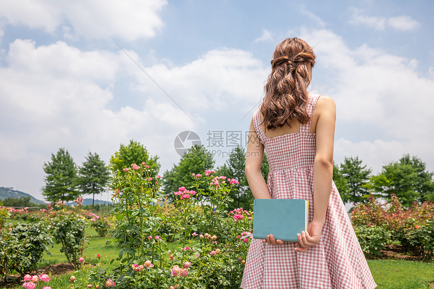 青年女性户外看书特写图片