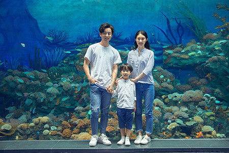 一家三口旅行年轻家庭参观海洋馆背景