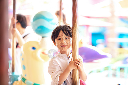 小男孩在游乐场坐旋转木马图片