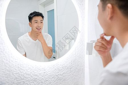 男性洗手间照镜子背景图片