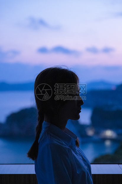 夏日黄昏美女窗边剪影图片