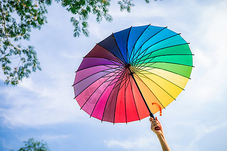 彩虹伞撑着伞的绿叶高清图片