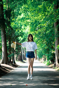 女孩走在林荫小道上背景图片