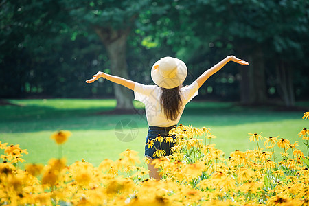 花海戴帽子女性背影背景图片