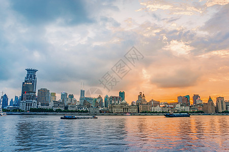 夕阳下的江边城市建筑背景