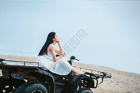 海边美女坐海边沙滩车上的女生背景