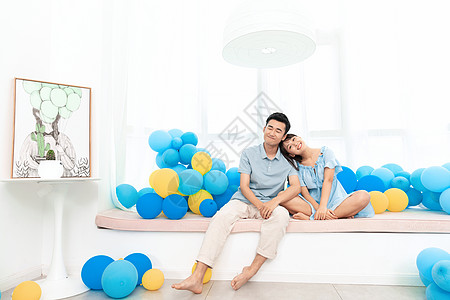 情侣坐在气球上一对情侣一起坐在飘窗台上背景