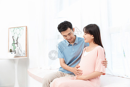 准爸爸摸着准妈妈肚子呵护孕妇背景图片