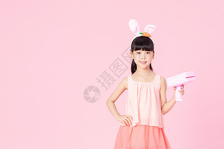 可爱小女孩戴着兔耳朵拿着玩具枪高清图片