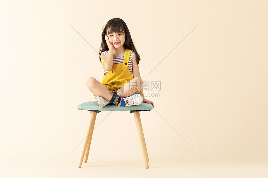 可爱女孩坐在椅子上害羞摸脸图片