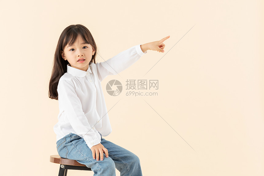 小女孩坐在椅子上玩耍图片