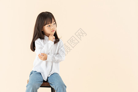 小女孩坐在椅子上玩耍高清图片