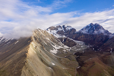 新疆山野雪山云雾航拍图片