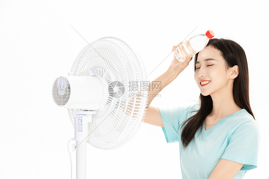 夏日美女拿矿泉水吹风扇图片