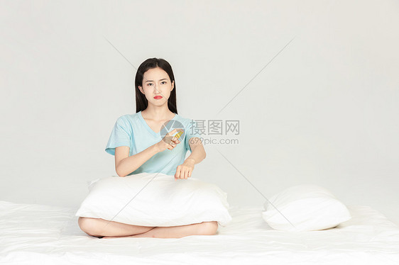 美女坐在床上用驱蚊水图片