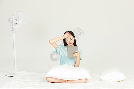女性坐在床上看平板图片