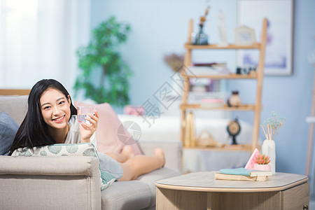 女孩开心喝水女性躺在沙发上背景