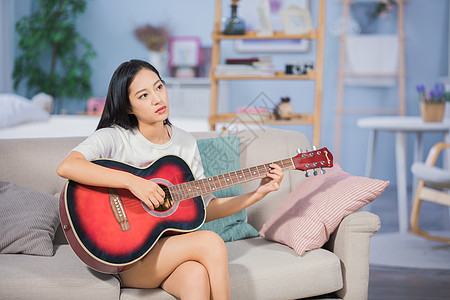 女性客厅弹吉他背景图片