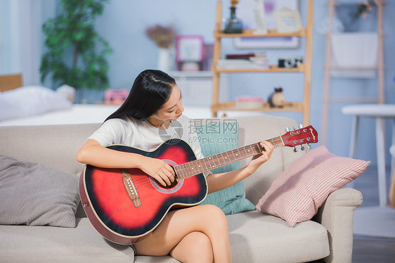 女性客厅弹吉他图片