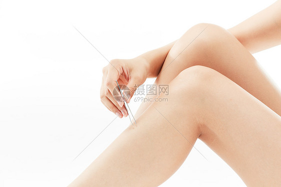 女性腿部涂抹脱毛膏特写图片