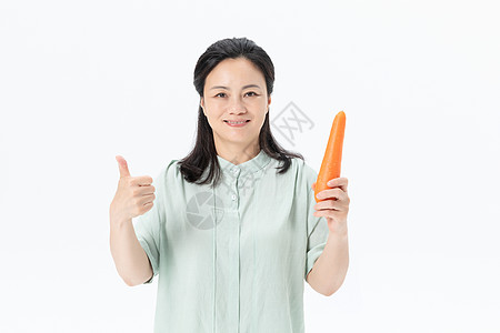中年女性手拿胡萝卜高清图片