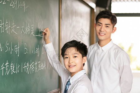 老师和学生微笑着在黑板上做题背景图片