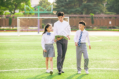 学生和老师老师和学生走在操场上讨论背景