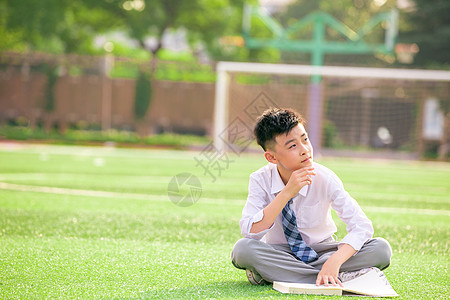 学习思考男孩学生坐在操场上思考背景