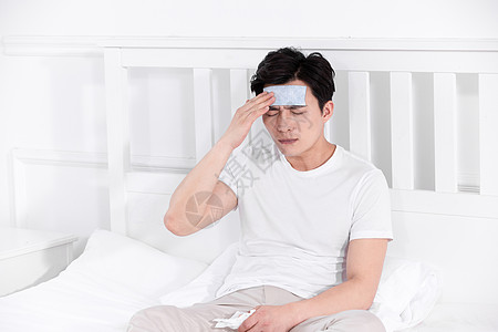 男子发烧感冒靠在床上休息正侧面高清图片