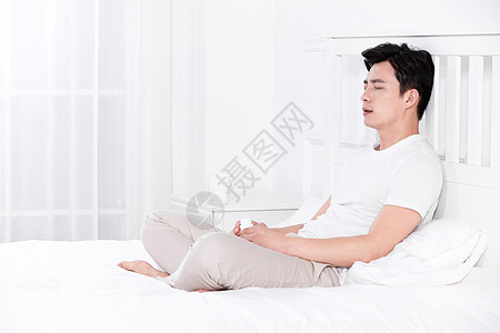 男子发烧感冒靠在床上休息图片