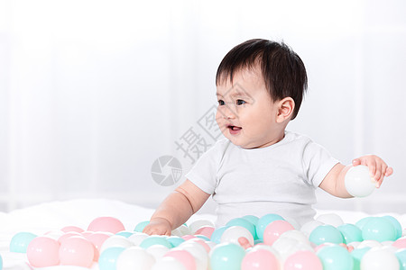 婴儿玩弄彩球特写背景图片
