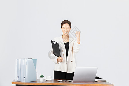 女性手拿文件夹在办公室手拿文件夹的商务女性背景