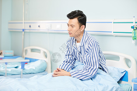 男病人坐在医院病床背景图片
